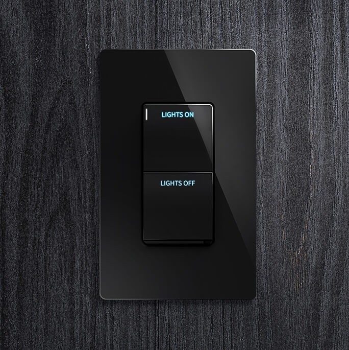 Black Cameo 2 Crestron rocker style lighting keypad with Lights On and Lights Off buttons on a dark wood wall